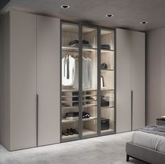 a bedroom with a bed, closet and clothes on the shelves in front of it