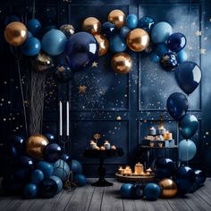 a room filled with blue and gold balloons, candles and cake on top of a table