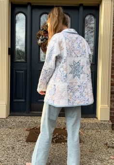 a woman standing in front of a door with her back to the camera, wearing pajamas and pink slippers