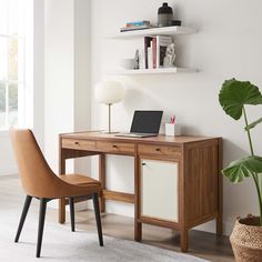 a desk with a laptop on it and a chair next to it in front of a window