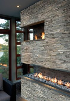 a fire place in the middle of a living room next to a couch and window