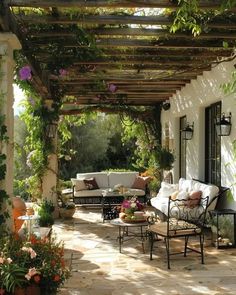 an outdoor living area with couches, tables and potted plants on the patio