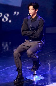 a young man sitting on top of a stool