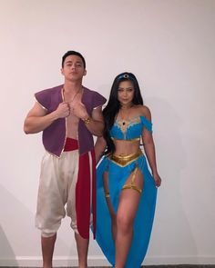 a man and woman in costume standing next to each other with their hands on the hips