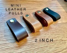 three leather pulls are shown on a table with the measurements for each one in different colors