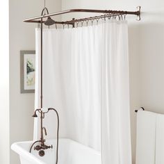 a bath tub sitting next to a white shower curtain