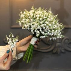 a woman holding a bouquet of white flowers