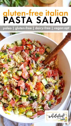 a pasta salad in a white bowl with a wooden spoon on the side and text overlay that reads gluten - free italian pasta salad