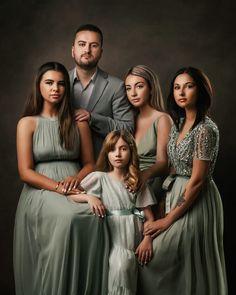 a family posing for a photo in front of a dark background