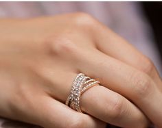 a woman's hand wearing a ring with three rows of diamonds on the band