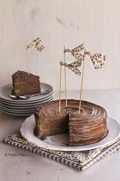 a chocolate cake on a plate with two small flags sticking out of it's top