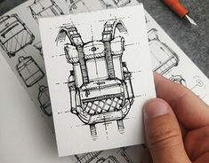 a hand holding a piece of paper with a drawing of a back pack on it