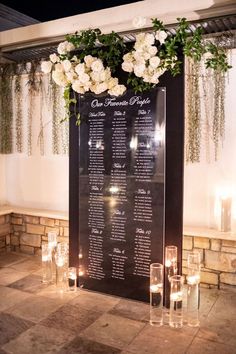 a table with candles and flowers on it in front of a sign that says guest information