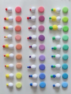 many different colored dots are arranged on a white surface