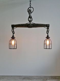 two light fixtures hanging from the ceiling with caged lights on them in a room