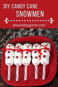 some marshmallows are on a red plate with candy canes in the shape of snowmen