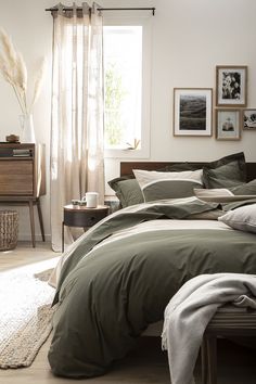 a bed with green sheets and pillows in a room