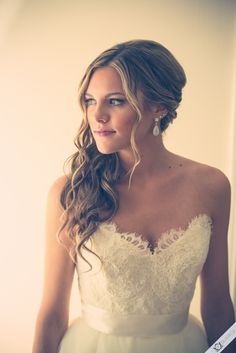 a woman in a wedding dress is posing for the camera with her hair pulled back