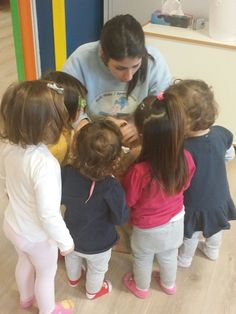 a woman is showing children how to use a cell phone