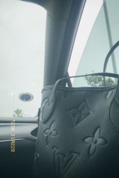 the interior of a car with a handbag hanging from it's side window