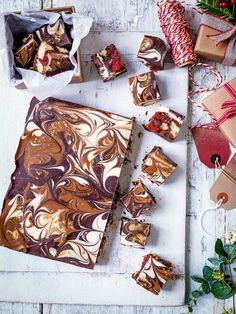 several pieces of chocolate cake sitting on top of a cutting board next to christmas decorations