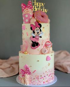 a three tiered birthday cake with minnie mouse on top