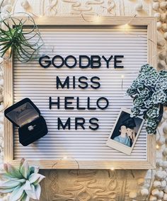 a sign that says goodbye miss hello mrs surrounded by succulents and other items