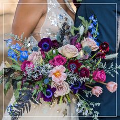 the bride and groom are holding their wedding bouquets with purple, blue and pink flowers