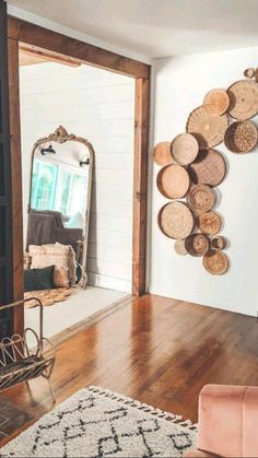 a living room filled with furniture and a mirror on top of a hard wood floor