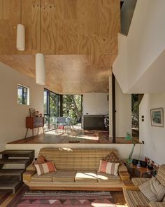 a living room with couches, tables and chairs on the floor in front of large windows