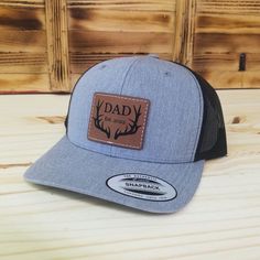 Celebrate the dads in your life with this custom laser engraved dad with deer antlers and established date leather patch hat. The hats are the popular trucker style snap-back that look great and are available in several colors - see available colors. Shipped in a full size box so you will receive your hat in perfect condition.  Looking for something different? We can make any custom patch for you, just message us! Item Care: Spot clean only. Do not machine wash or dry. As this item is a custom m Outdoor Hats With Leather Patch For Father's Day, Outdoor Leather Patch Hat For Father's Day, Leather Patch Hat, Custom Patch, Patch Hat, Custom Patches, Deer Antlers, New Dads, Snap Backs