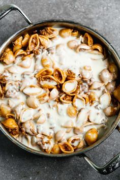 a skillet filled with pasta covered in white sauce