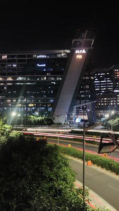 a city street at night with tall buildings in the background