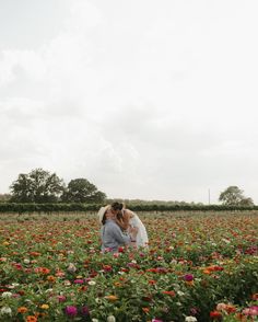 two people kissing in a field full of flowers