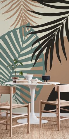 two chairs and a table in front of a wall with palm leaves painted on it