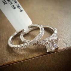 two wedding rings sitting on top of a wooden table