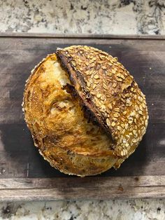 a loaf of bread sitting on top of a wooden cutting board