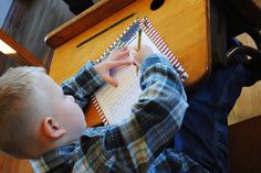 a young boy sitting at a desk writing on a piece of paper