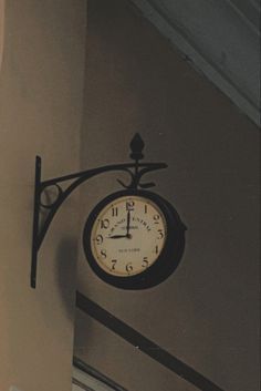 a clock hanging from the side of a wall