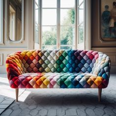 a multicolored couch sitting in front of a window