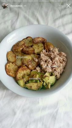 a white bowl filled with food on top of a table