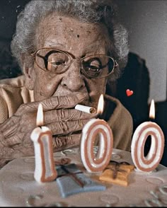 an old woman blowing out candles on her birthday cake with the number 10 written in it