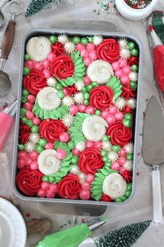 a cake decorated with red, white and green icing in a pan on a table