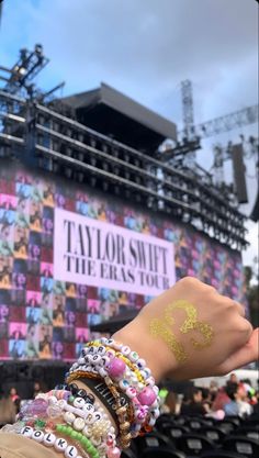 a person's arm covered in bracelets and jewelry at a concert with the words taylor street on it