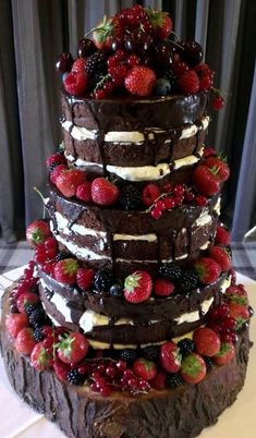 a triple layer chocolate cake with strawberries on top