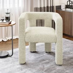 a white chair sitting on top of a rug in a living room next to a table