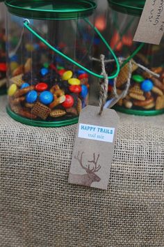 three glass jars filled with different types of candy and candies on top of a burlap table cloth