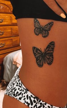 two butterflies on the back of a woman's lower body, one is black and white