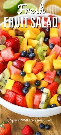 fresh fruit salad in a white bowl with strawberries, kiwis and blueberries