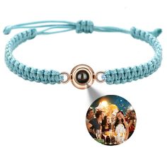 a bracelet with an image of people on it and a circle charm attached to the clasp